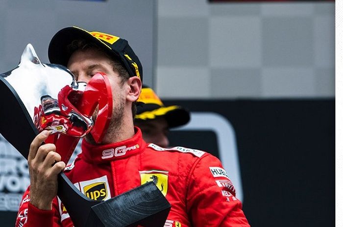 Sebastian Vettel (Ferrari) saat mencium trofi yang ia dapatkan setelah finis sebagai runner up F1 GP Jerman 2019, Minggu (28/7/2019)