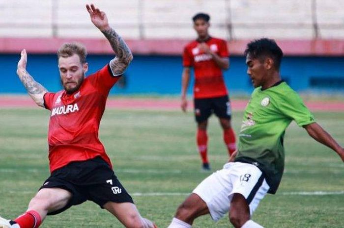 Pemain asing Madura United, Jacob Papper (kiri) berduel dengan pemain Sinar Harapan, Sidoarjo (klub Liga 3) dalam laga uji coba di Stadion Gelora Delta, Sidoarjo, Jumat (18/9/2020). 