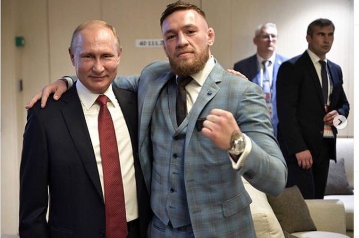 Presiden Rusia, Vladimir Putin (kiri) saat berpose dengan Bintang UFC yang berkarier di kelas ringan, Conor McGregor (kanan). Keduanya bertemu di Final Piala Dunia 2018 di Moskow.