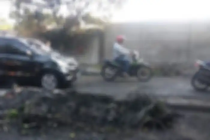 Pemotor harus hati-hati melewati jalan Slipi I, masih banyak batu dan jelaga.