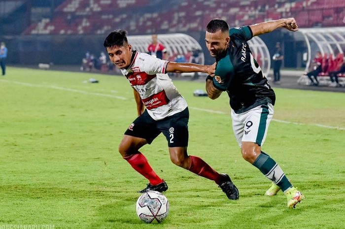 Pemain Madura United sedang berebut bola dengan pemain Tira Persikabo pada laga pekan ke-34 di Stadion Kapten I Wayan Dipta, Gianyar, Selasa (29/3/2022).