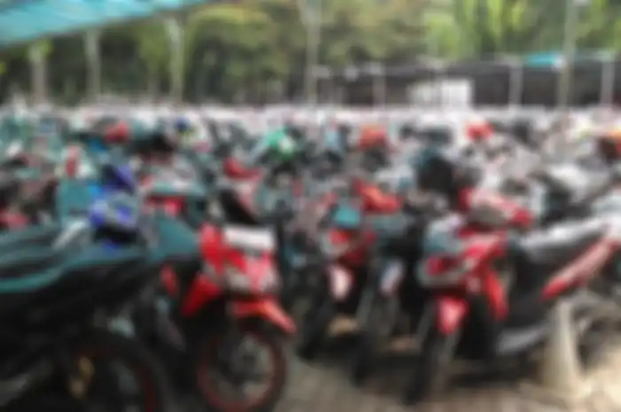 Ilustrasi meletakan helm di kaca spion saat parkir motor.