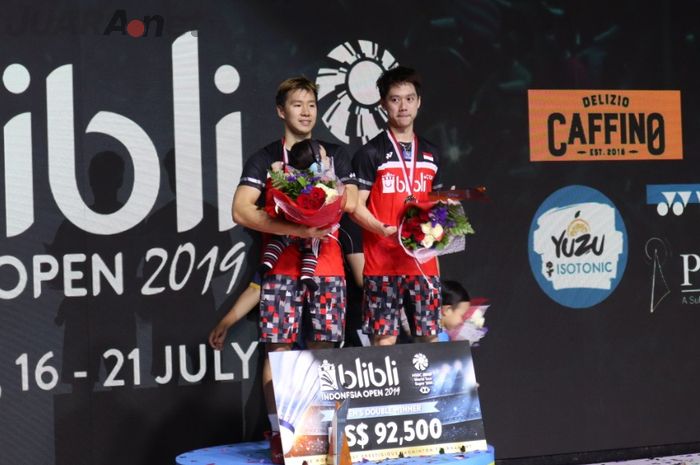 Pasangan ganda putra Indonesia, Marcus Fernaldi Gideon/Kevin Sanjaya Sukamuljo, berpose di podium juara Indonesia Open 2019 di Istora Senayan, Jakarta, Minggu (21/7/2019)