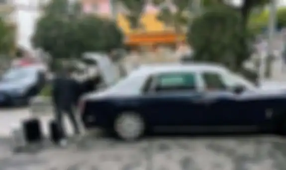 Miliarder memasukkan koper berisi uang ke mobil 