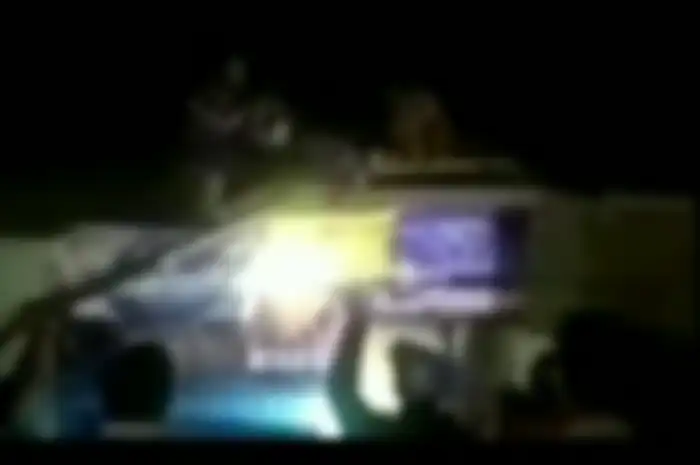 Warga mengevakuasi motor yang tersangkut di atap rumah warga.
