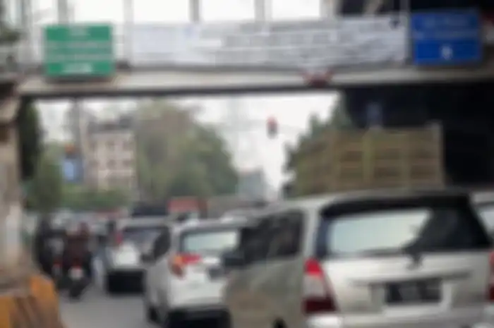 Spanduk kebijakan perluasan ganjil-genap yang terpasang di JPO Jalan DI Pandjaitan, Jakarta Timur.