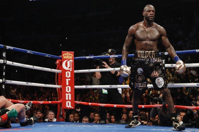 Momen saat Deontay Wilder (kanan) menjatuhkan  Tyson Fury (kiri) dalam pertarungan tinju yang digela