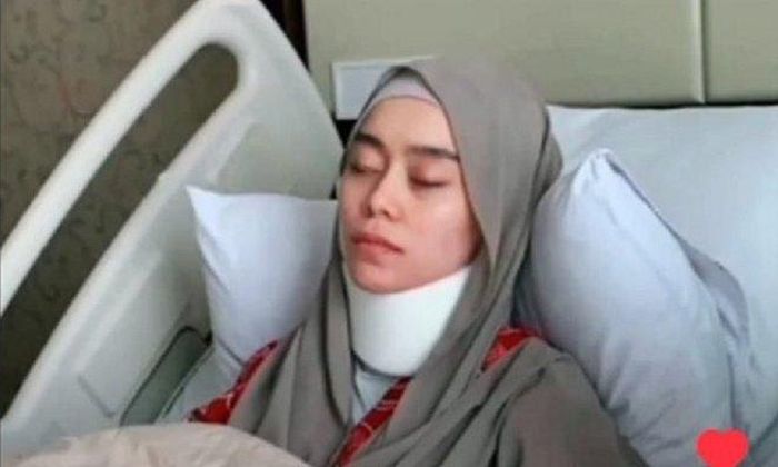 Potret Lesti yang duduk di kursi roda. Mata kirinya tampak masih ada bekas lebam coklat.
