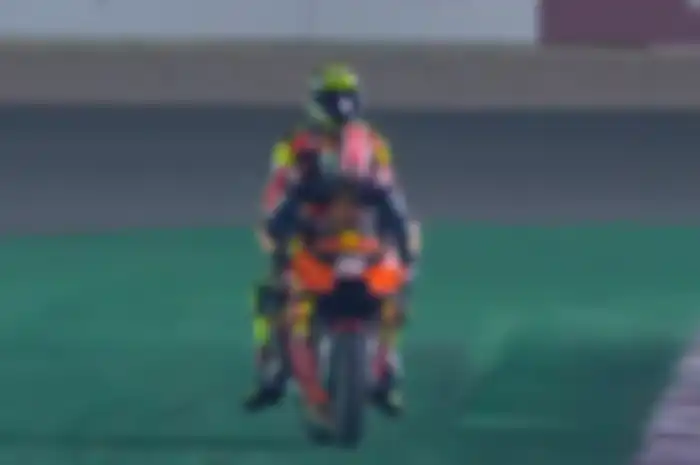 Usai terjatuh di lap terakhir MotoGP Qatar, Andrea Iannone dibonceng Johann Zarco menuju paddock.