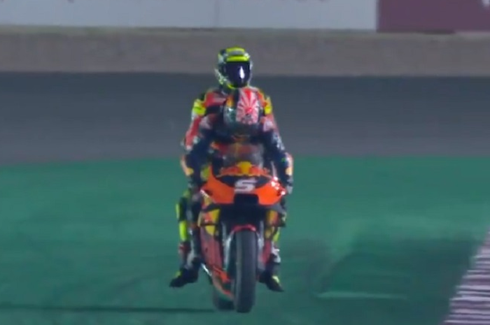 Usai terjatuh di lap terakhir MotoGP Qatar, Andrea Iannone dibonceng Johann Zarco menuju paddock.