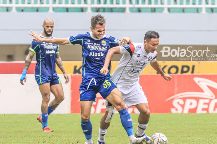 Bek sayap kiri Persib Bandung, Rezaldi Hehanussa (kiri), sedang merebut bola yang dikuasai pemain Arema FC bernama Dendi Santoso (kanan) dalam laga pekan ke-26 Liga 1 2022 di Stadion Pakansari, Bogor, Jawa Barat, Kamis (23/2/2023).