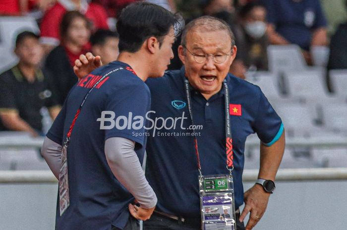 Pelatih timnas Vietnam, Park Hang-seo (kanan), tampak sedang berkomunikasi dengan asistennya saat memantau para pemainnya bertanding dalam laga leg pertama semifinal Piala AFF 2022 di Stadion Gelora Bung Karno, Senayan, Jakarta, 6 Januari 2023.