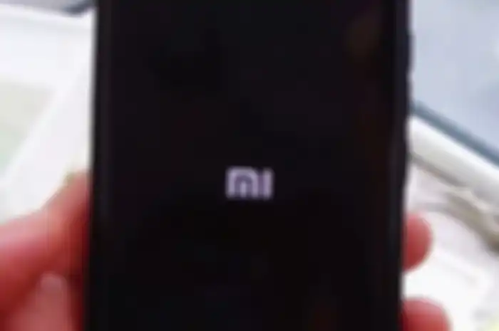 Tangkapan layar video yang menampilkan layar dengan logo Mi dan keterangan dukungan HarmonyOS di smartphone Xiaomi.