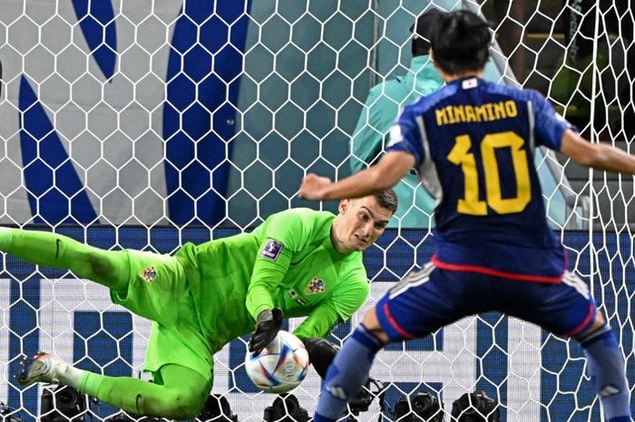 Kiper timnas Kroasia, Dominik Livakovic, mengeblok tendangan penalti Takumi Minamino dalam duel Piala Dunia 2022 di Al Janoub Stadium (5/12/2022).