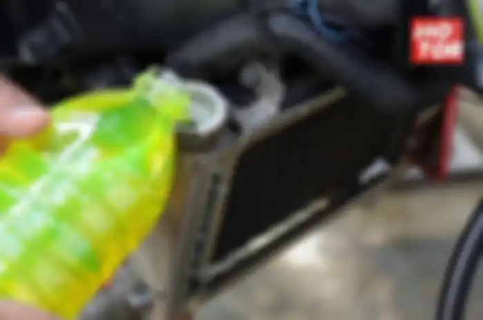 Ilustrasi mengisi air radiator di motor.