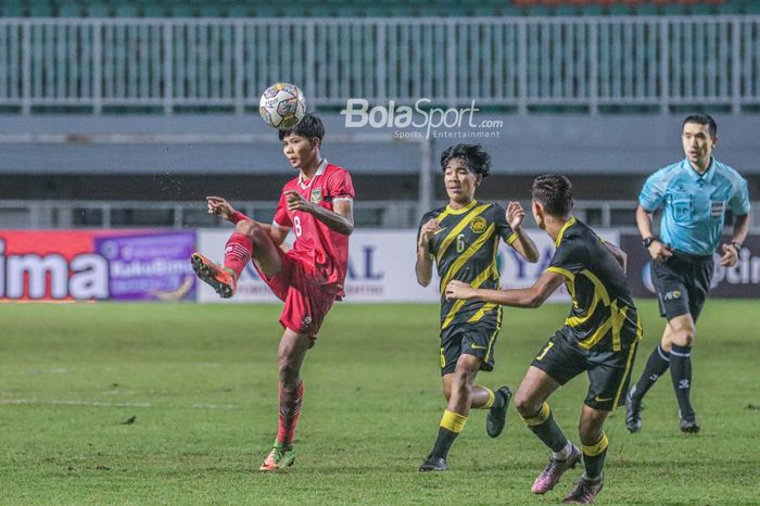 Pemain timnas U-17 Indonesia, Arkhan Kaka Putra (kiri), sedang menendang dan dikawal pilar timnas U-17 Malaysia bernama Muhammad Afiq Danish (tengah) dalam laga Kualifikasi Piala Asia U-17 2023 di Stadion Pakansari, Bogor, Jawa Barat, 9 Oktober 2022.