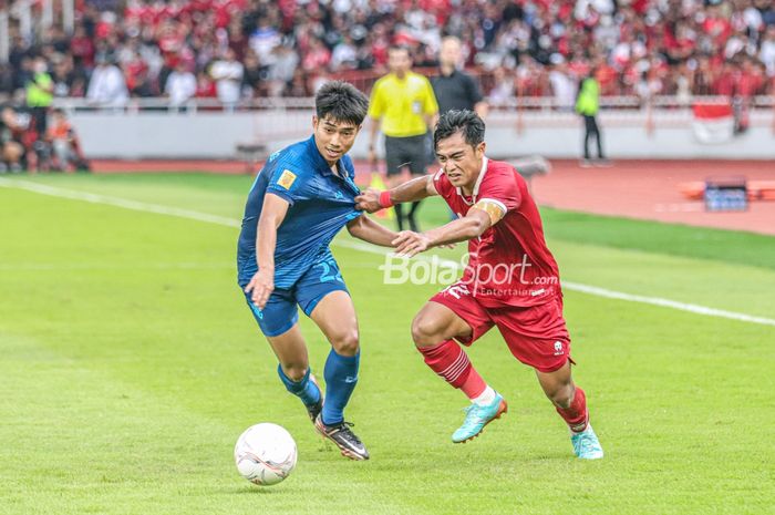 Bek sayap kiri timnas Indonesia, Pratama Arhan (kanan), sedang berebut bola dengan pemain timnas Thailand bernama Channarong Promsrikaew (kiri) dalam laga Piala AFF 2022 di Stadion Utama Gelora Bung Karno, Senayan, Jakarta, 29 Desember 2022.