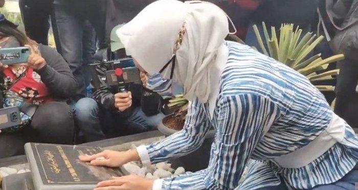 Angelina Sondakh saat ziarah ke makam Adjie Massaid. 