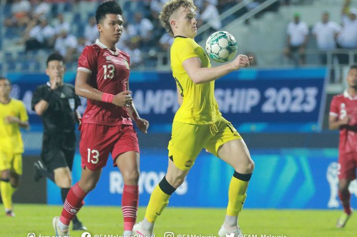 Pemain Malaysia, Fergus Tierney (kanan), saat berduel dengan bek Timnas U-23 Indonesia, Kadek Arel (kiri).