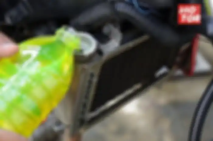 Ilustrasi mengisi air radiator di motor.