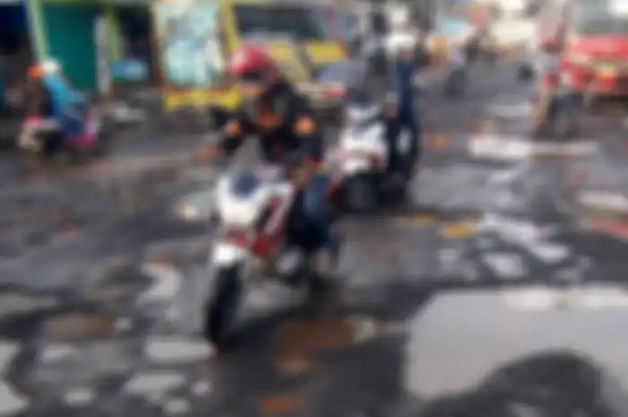 Ilustrasi. Hati-hati melewati jalan berlubang ketika musim hujan, tiga komponen di motor ini rawan rusak!