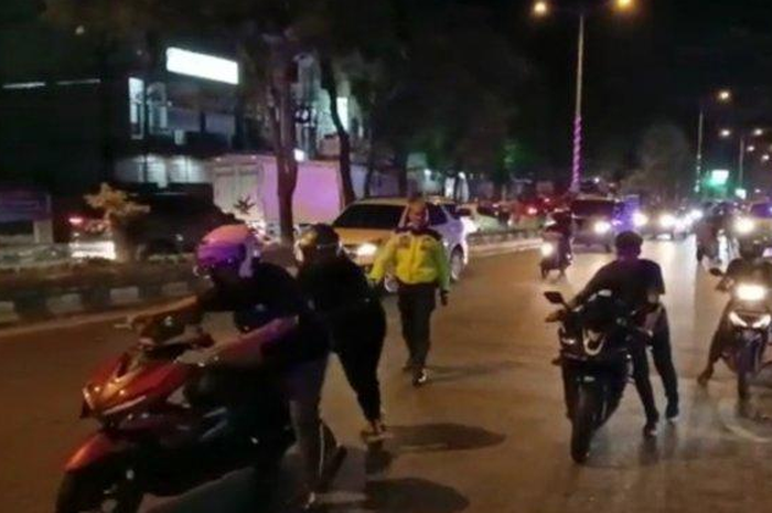 Para pemuda tampak mendorong motor mereka lantaran menggunakan knalpot brong.
