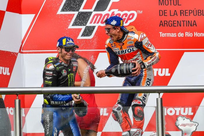 Momen saat Valentino Rossi (kiri) dan Marc Marquez (kanan) berselebrasi di atas podium MotoGP Argentina 2019.