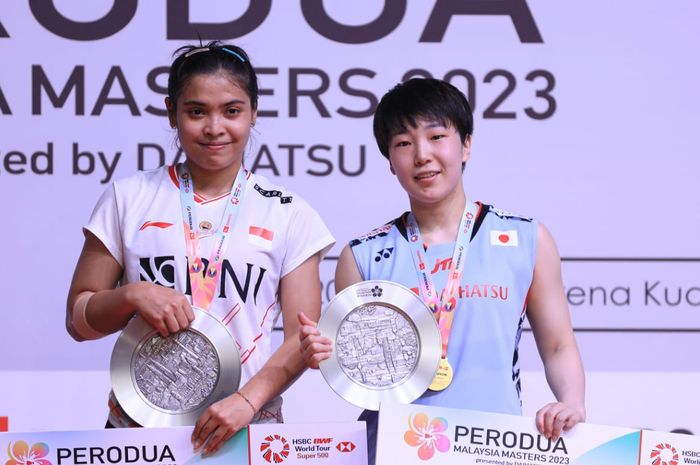 Pebulu tangkis tunggal putri Indonesia, Gregoria Mariska Tunjung (kiri) dan Akane Yamaguchi (Jepang) di podium Malaysia Masters 2023 di Axiata Arena, Kuala Lumpur, Minggu (28/5/2023).