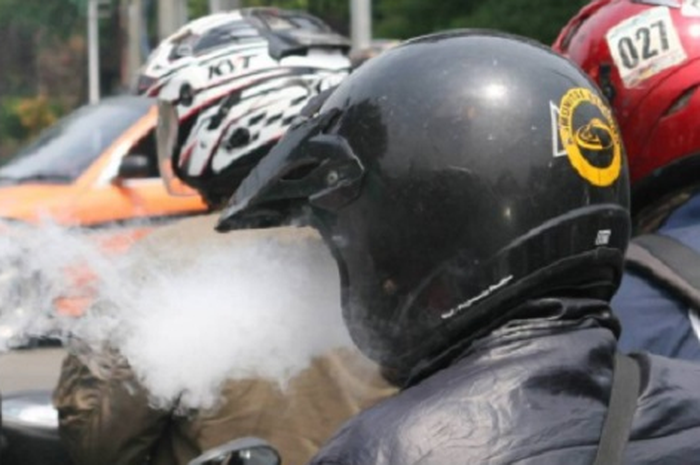Naik motor sambil merokok  mengganggu orang lain