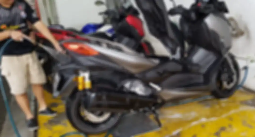 Ilustrasi mencuci motor dengan semprotan air