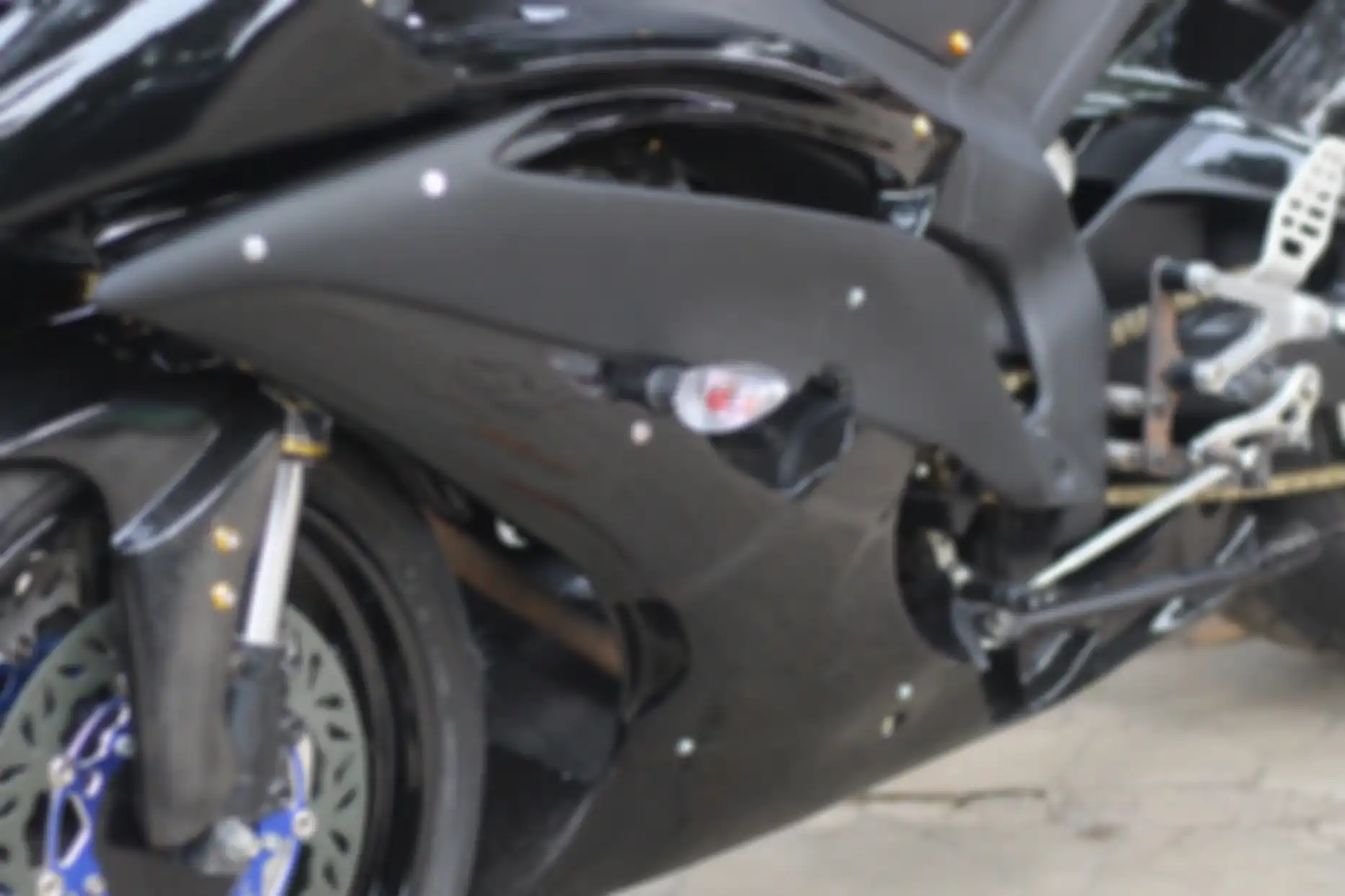 Fairing bagian samping juga dibentuk dengan detail kisi-kisi lubang seperti R6