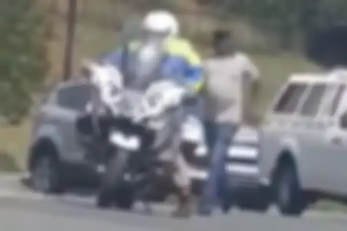 Polisi yang bersusah payah menaiki motornya sendiri