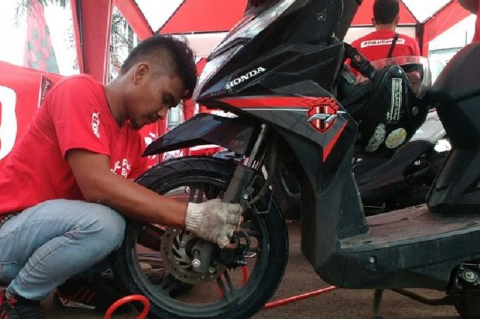 Ilustrasi ganti ban motor baru.