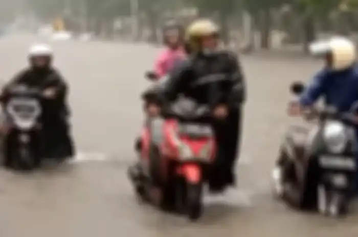 Ilustrasi motor dituntun menerobos banjir