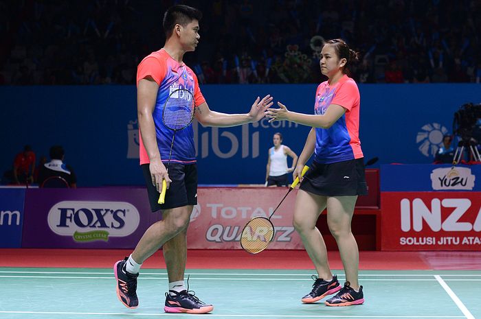 Pasangan ganda campuran Indonesia, Praveen Jordan/Melati Daeva Oktavianti, melakukan tos saat melawan wakil Jerman, Mark Lamsfuss/Isabel Herttrich, pada babak kesatu turnamen Indonesia Open 2019 di Istora Senayan, Jakarta, Senin (16/7/2019).