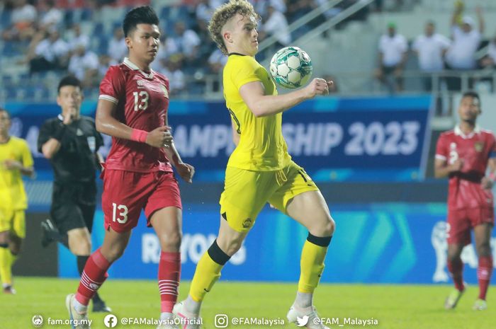 Pemain Malaysia, Fergus Tierney (kanan), saat berduel dengan bek Timnas U-23 Indonesia, Kadek Arel (kiri).