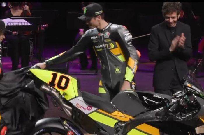 Pembalap Mooney VR46 Racing Team, Marco Bezzecchi dan Luca Marini, membuka tirai yang menutupi motor Ducati Desmosedici GP yang akan mereka pakai pada MotoGP 2022. Valentino Rossi (dua dari kanan) selaku pemilik tim hadir pada peluncuran yang dihelat secara virtual pada Kamis (24/2/2022).