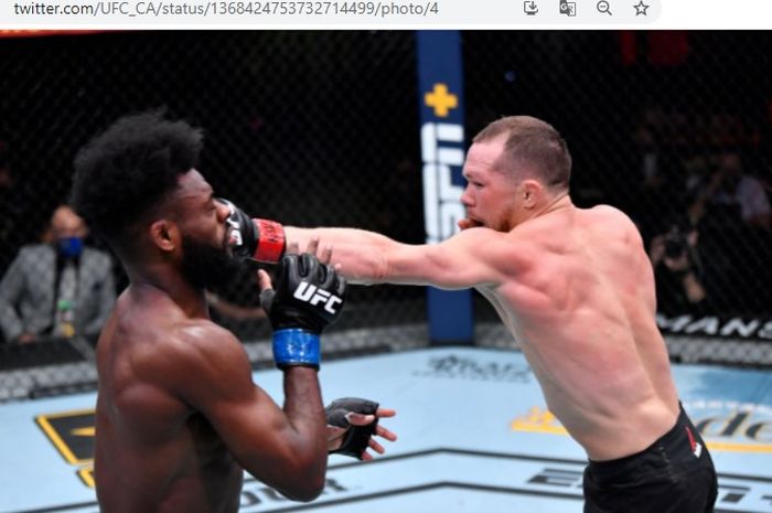 Petr Yan (kanan) saat mendaratkan pukulan tepat mengenai wajah Aljamain Sterling (kiri) saat bentrok pertama mereka pada ajang UFC 259, Minggu (7/3/2021).