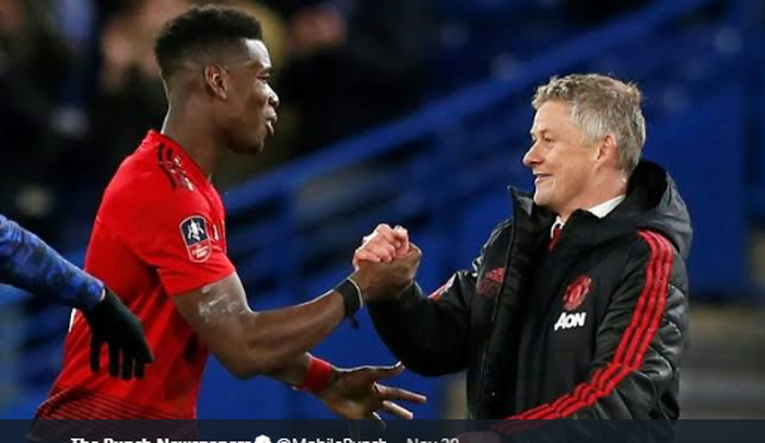 Gelandang Manchester United, Paul Pogba (kiri) bersalaman dengan pelatih Ole Gunnar Solskjaer.