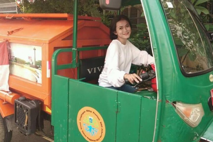 Selhha Purba, petugas PPSU cantik saat berpose di motor pengangkut sampah.