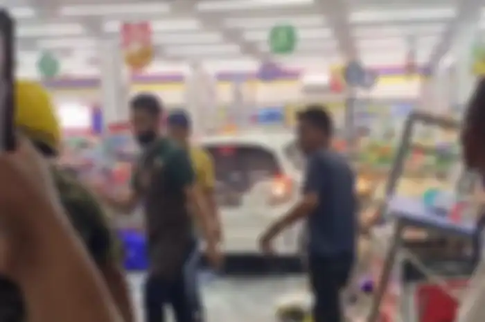 Kaca minimarket berantakan mobil masuk ke dalam minimarket dan menghancurkan rak dagangan.