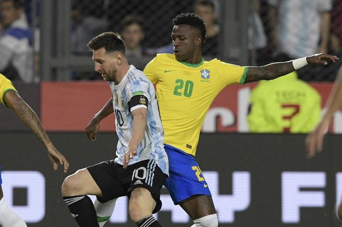 Lionel Messi berduel dengan Vinicius Junior dalam bentrokan timnas Argentina vs timnas Brasil di Kualifikasi Piala Dunia 2022 (16/11/2021). Copa America 2024 akan menjadi panggung Messi vs Vini demi trofi turnamen dan Ballon d'Or.