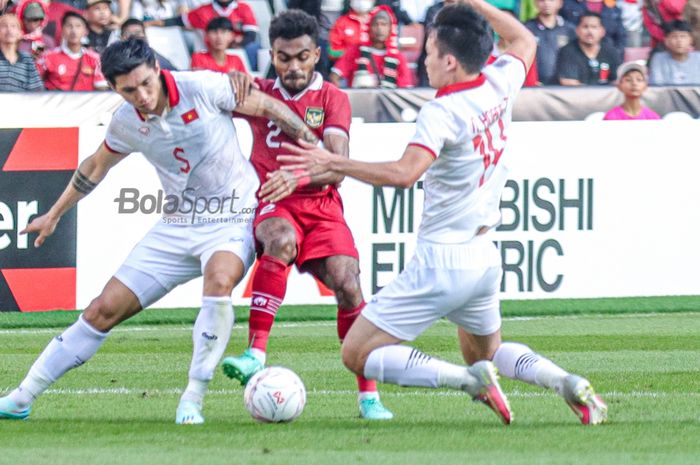 Pemain timnas Indonesia, Yakob Sayuri (tengah), tampak sedang berebut bola dengan Doan Van Hau (kiri) sebagai bek sayap kiri timnas Vietnam saat berlaga pada leg pertama semifinal Piala AFF 2022 di Stadion Gelora Bung Karno, Senayan, Jakarta, 6 Desember 2023.