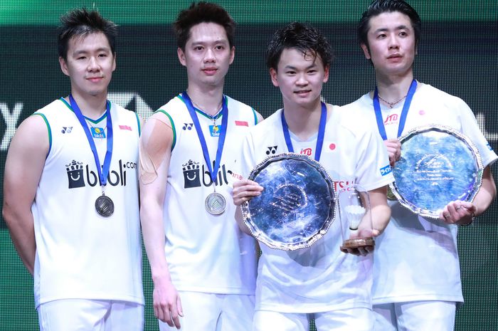 Pasangan ganda putra Indonesia, Marcus Fernaldi Gideon/Kevin Sanjaya Sukamuljo (kiri), berpose bersama Hiroyuki Endo/Yuta Watanabe (Jepang) di atas podium kampiun All England Open 2020,  Arena Birmingham, Inggris, Minggu (15/3/2020).