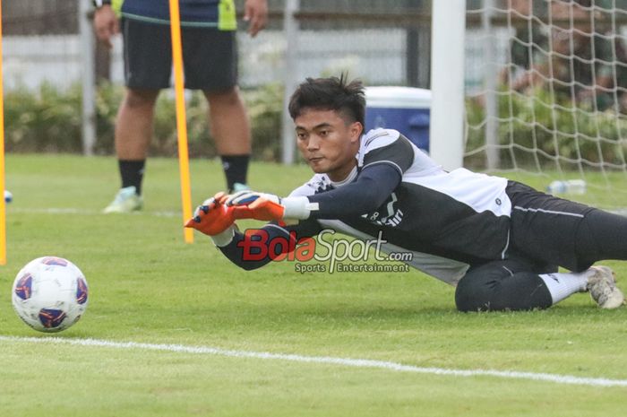 Kiper timnas Indonesia, Ernando Ari Sutaryadi, sedang menangkap bola dalam sesi latihan di Lapangan A, Senayan, Jakarta, Sabtu (31/8/2024).