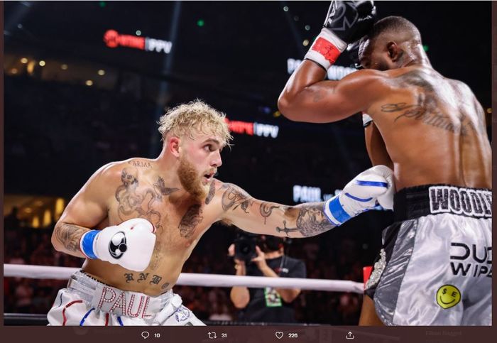 Momen Jake Paul (kiri) melakukan body shot ke arah Tyron Woodley (kanan) dalam duel ulang antara mereka berdua di Amalie Arena, Tampa, Florida, Amerika Serikat, Sabtu (18/12/2021).