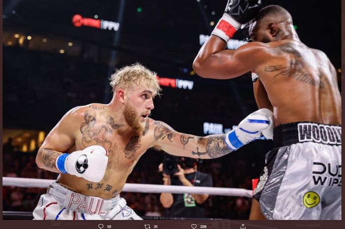 Momen Jake Paul (kiri) melakukan body shot ke arah Tyron Woodley (kanan) dalam duel ulang antara mereka berdua di Amalie Arena, Tampa, Florida, Amerika Serikat, Sabtu (18/12/2021).