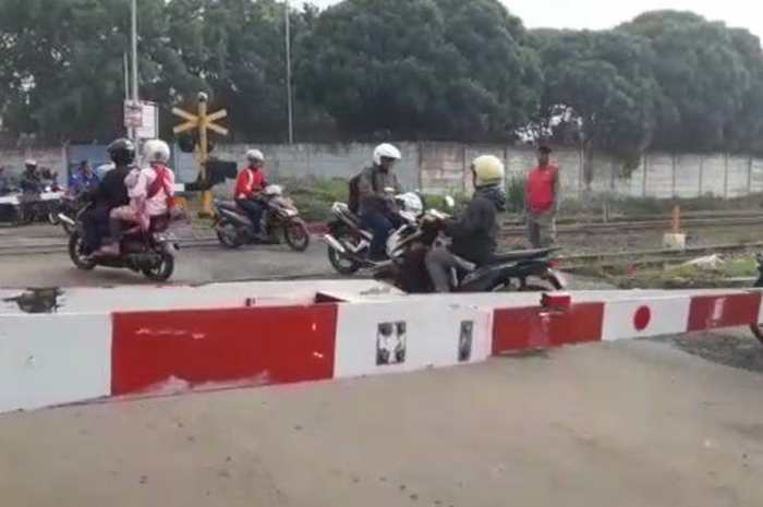 Ilustrasi pemotor menerobos palang pintu kereta api