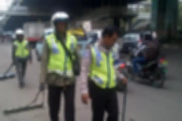 Relawan Tim Saber tengah membersihkan ranjau paku.