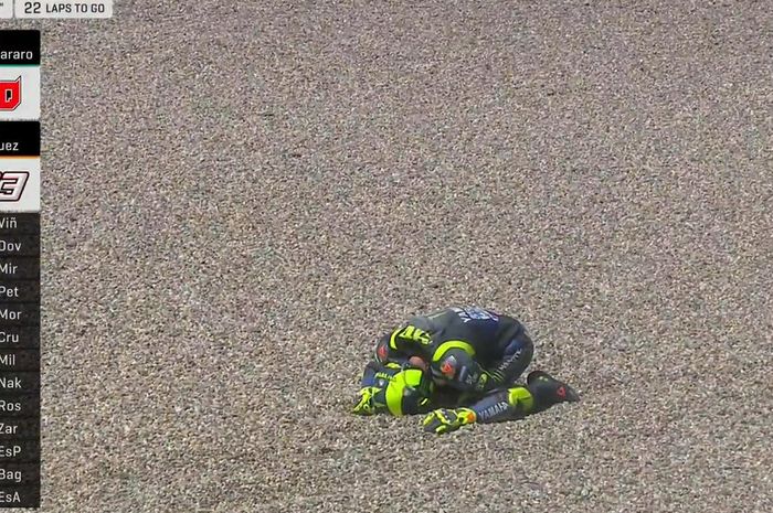 Momen saat Valentino Rossi meringkuk di area gravel Sirkuit Assen setelah mengalami insiden pada sesi balapan GP Belanda 2019, Minggu (30/6/2019)